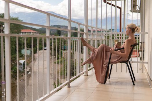 The girl sits on the balcony of the mountains and the blue sky on the background of beauty balcony female, outdoor relax view enjoy, leisure travel. Inspiration sky romantic hotel