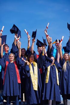 high school students graduates tossing up hats over blue sky.