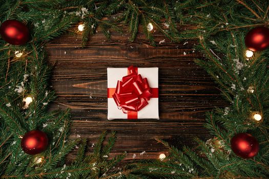 gift box and a Christmas garland on a wooden background photo with a copy-space.