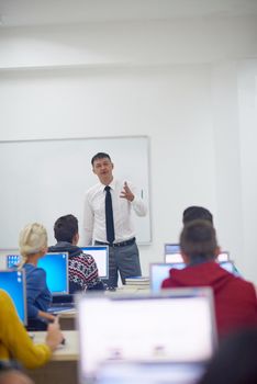 group of students with teacher in computer lab classrom learrning lessons,  get help and support