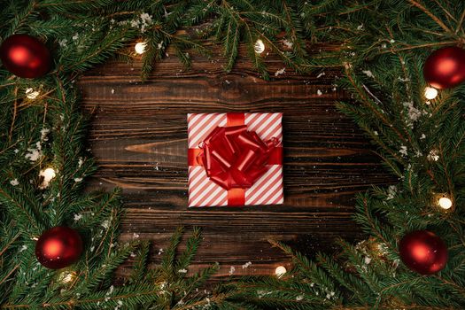 gift box and a Christmas garland on a wooden background photo with a copy-space.