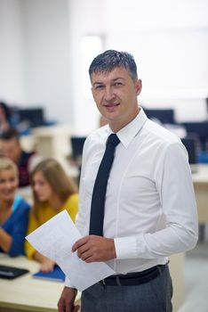 group of students with teacher in computer lab classrom learrning lessons,  get help and support