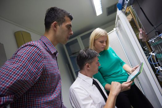 business people group, network engeneers working in network server room on tablet computer