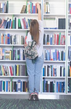 smart looking famale student girl  in collage school library selecting book to read