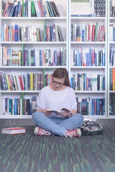 smart looking famale student girl  in collage school library reading book