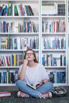 smart looking famale student girl  in collage school library reading book