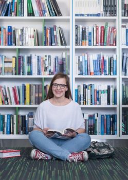 smart looking famale student girl  in collage school library reading book