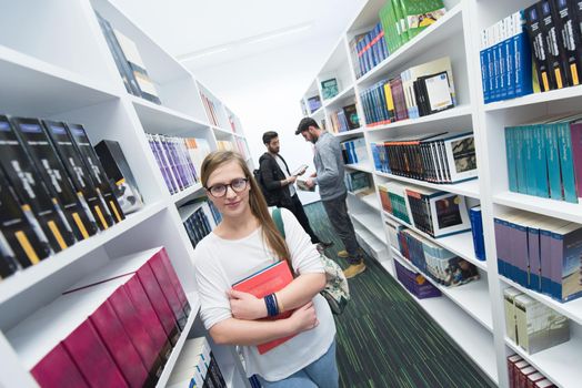 happy students group  in school  library selecting books to read and walking