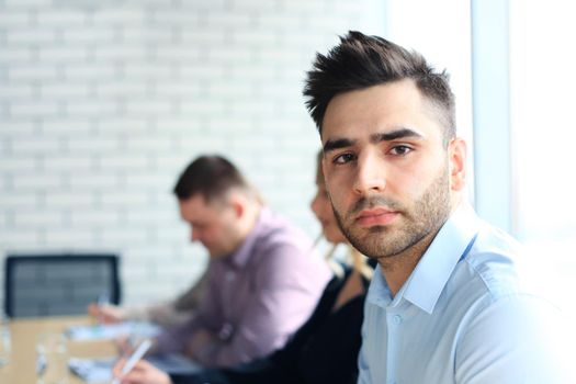 Businessman with colleagues in the background in office