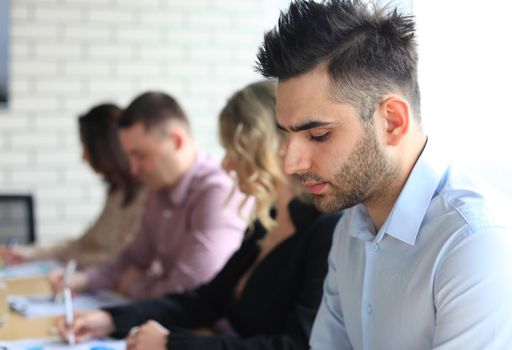 Businessman with colleagues in the background in office