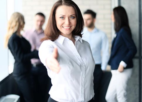 woman with an open hand ready for handshake in office.