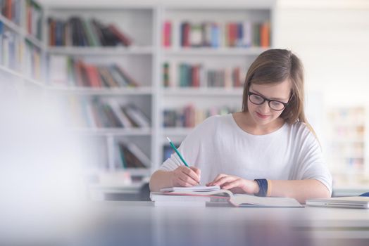 female student study in school library, using laptop and searching for informations on internet