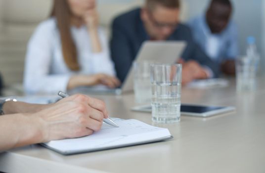 Unrecognizable business person analyzing graphs and taking notes