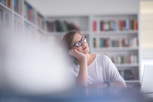 female student study in school library, using laptop and searching for informations on internet