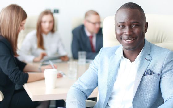 Happy smart business man with team mates discussing in the background