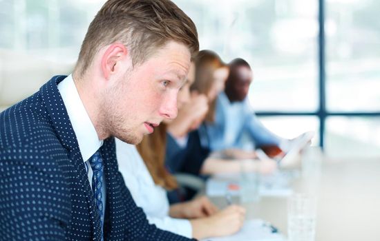 Businessman with colleagues in the background in office