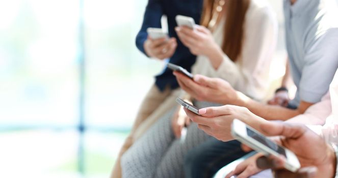 Group of students watching smartphones. Young people addiction to new technology trends.