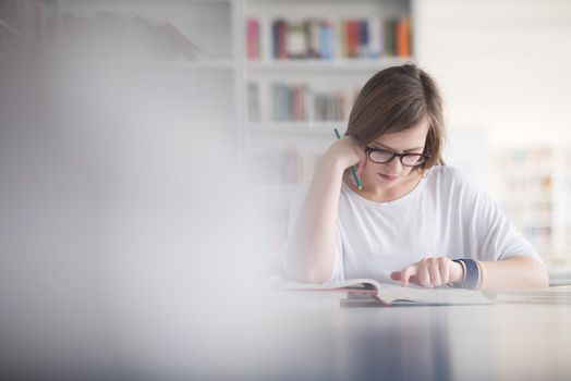 female student study in school library, using laptop and searching for informations on internet