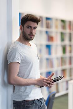 student preparing exam and learning lessons in school library, making research on tablet  and browse internet