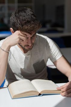 Student reading book in school library. Study lessons for exam. Hard worker and persistance concept.