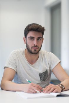 male student taking notes in classroom. business education concept, casual young businessman on seminar training