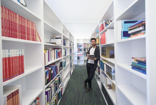 portrait of student in school  library with tablet computer. Database and archive management business concept