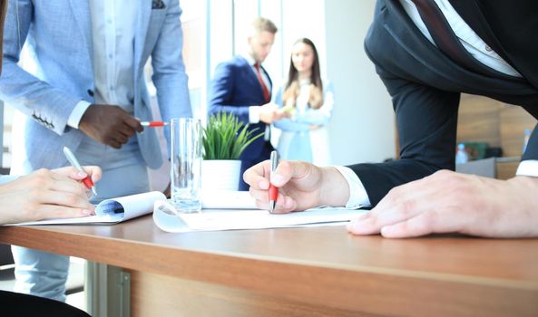 Image of business team sitting at the table and discussing a new project