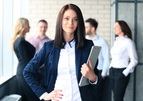 business woman with her staff, people group in background at modern bright office indoors