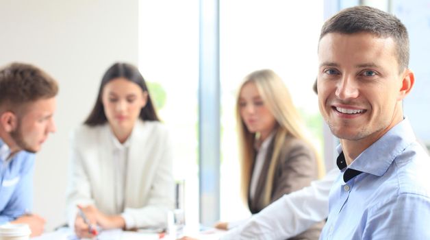 Businessman with colleagues in the background in office