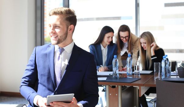 Businessman with colleagues in the background in office