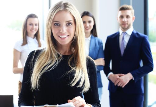 business woman with her staff, people group in background at modern bright office indoors.