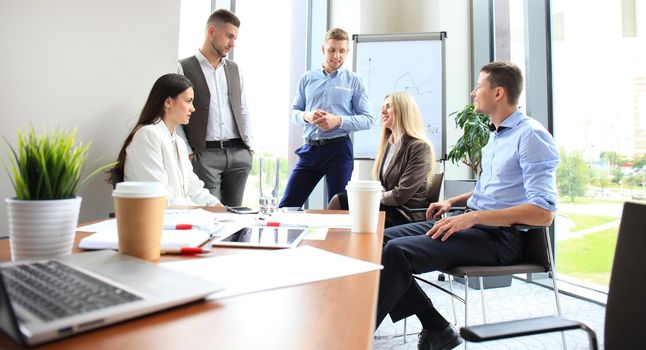 Team young professionals having casual discussion in office. Executives having friendly discussion during break.