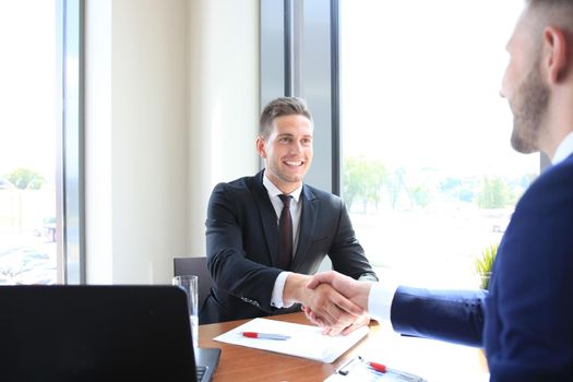 Business handshake. Two businessman shaking hands in the office.