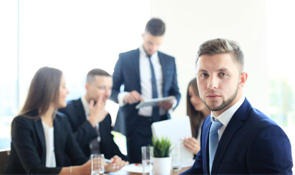 Businessman with colleagues in the background in office