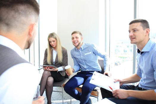 Creative people looking at project plan laid out on floor. Business associates discussing new project plan in modern office.