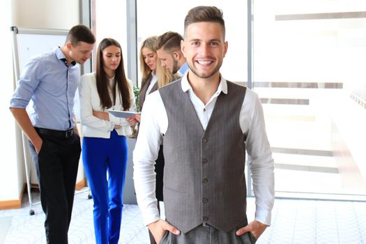 Businessman with colleagues in the background in office