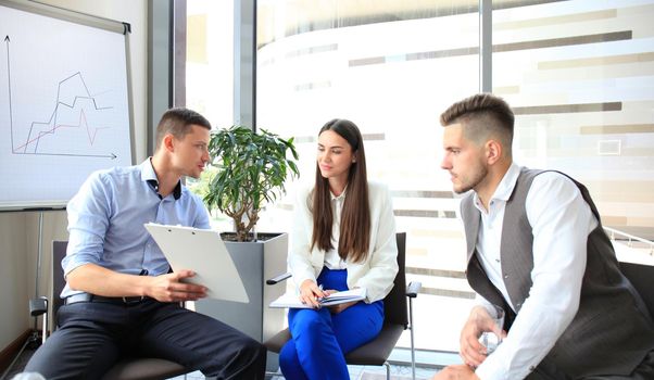 Group of young business professionals having a meeting. Diverse group of young designers smiling during a meeting at the office.