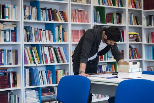 Student reading book in school library. Study lessons for exam. Hard worker and persistance concept.