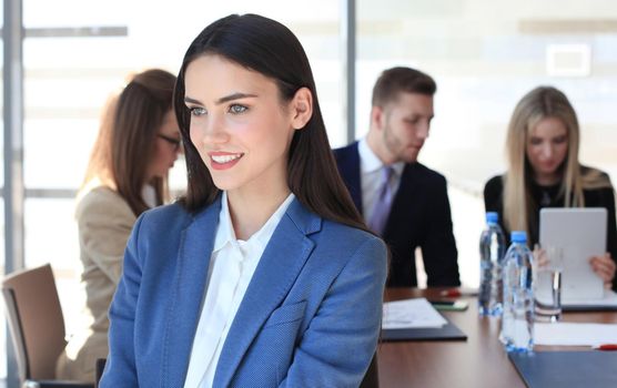 business woman with her staff, people group in background at modern bright office indoors.