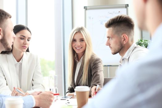 A group of business people at a meeting on the background of office. Focus on a beautiful blonde