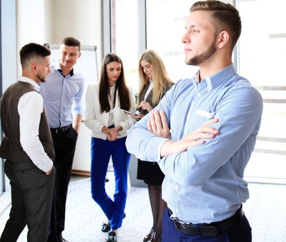 Businessman with colleagues in the background in office.