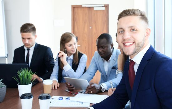 Businessman with colleagues in the background in office