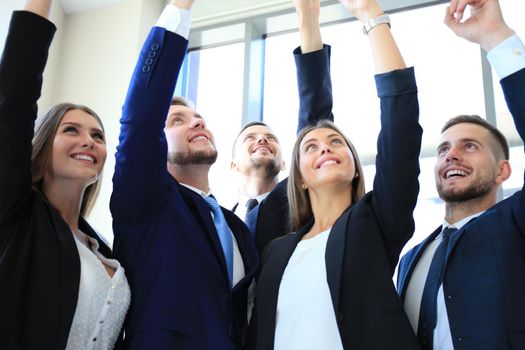 Group of five business people in a row pointing and looking up