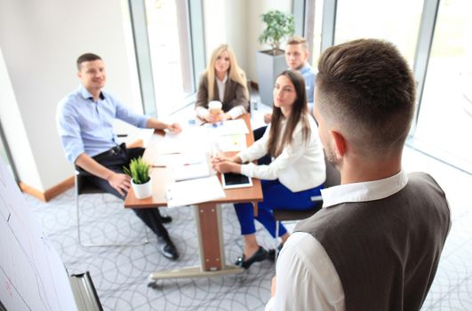 Businessman giving a presentation on flipchart. Teamwork concept