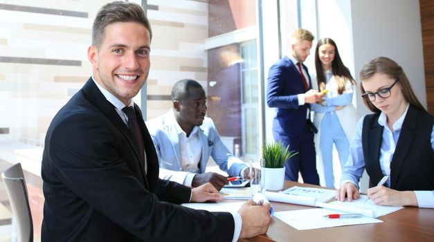 Businessman with colleagues in the background in office