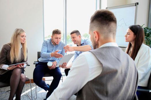 Group of young business professionals having a meeting. Diverse group of young designers smiling during a meeting at the office.