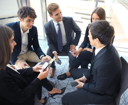 Creative business people meeting in circle of chairs.