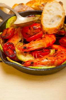 roasted shrimps on cast iron skillet  with zucchini and tomatoes