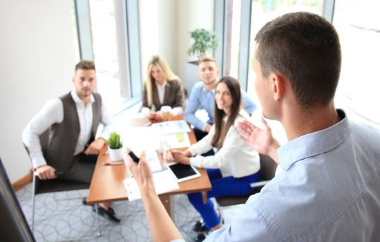 Businessman giving a presentation on flipchart. Teamwork concept