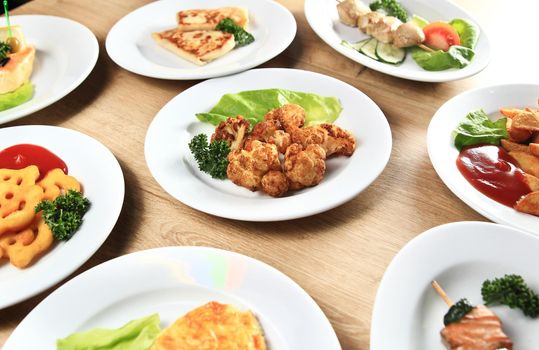 many delicious dishes on a table in the restaurant with the main dish in the middle